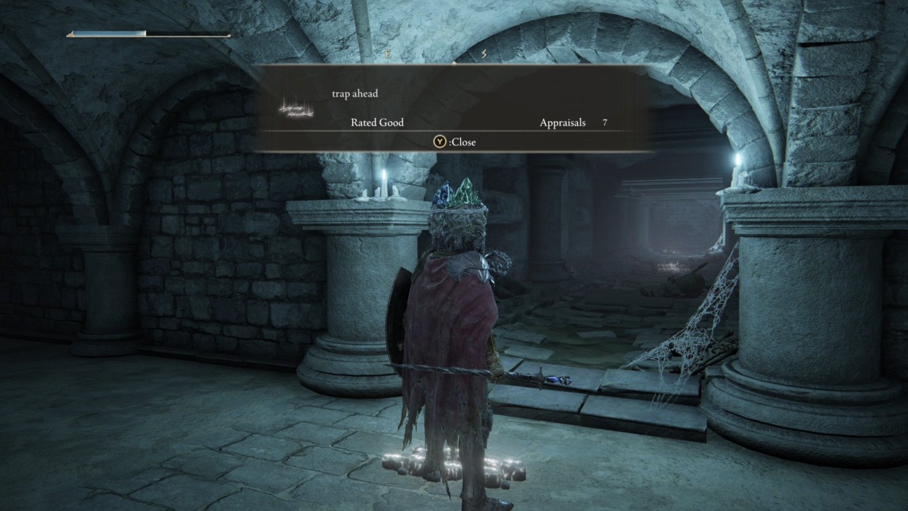 A screenshot of the game Elden Ring displaying the messages feature. A message is being read, it says 'trap ahead' as the player faces an open tunnel.